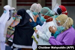 Petugas kesehatan dan dokter berdoa untuk rekan mereka, korban virus corona COVID-19, di Rumah Sakit Zainoel Abidin di Banda Aceh pada 29 September 2020. (Foto: AFP/Chaideer Mahyuddin)