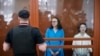 Sutradara teater Zhenya Berkovich (kanan) dan penulis naskah drama Svetlana Petriychuk melihat ke arah wartawan saat meraka berdiri dalam kotak kaca di ruang pengadilan di Moskow, pada 8 Juli 2024. (Foto: AP/Alexander Zemlianichenko)