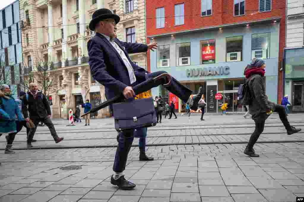 About 300 participants in black suits and suitcases take part in a &#39;Silly Walk&#39; referring to a famous sketch by British comedy group Monty Python at Brno, south Moravia, Czech Republic.