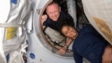 In this photo provided by NASA, Boeing Crew Flight Test astronauts Butch Wilmore, left, and Suni Williams pose inside the International Space Station's Harmony module and Boeing's Starliner spacecraft on June 13, 2024. (NASA via AP)