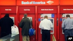 FILE - Customers use ATMs at a Bank of America branch office in Boston, Oct. 16, 2009. (AP Photo/Lisa Poole, File)