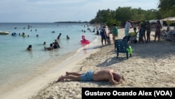 Turistas disfrutan de la playa del cayo venezolano de Playuela, en el estado Falcón, la tarde del jueves 24 de agosto de 2023.