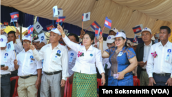 Candlelight Party's supporters and activists hold Cambodia's national flag and the party's flag during the party's congress in Siem Reap province, Feb. 11, 2023.