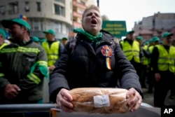 FILE - A woman holds bread during a farmers protest in Bucharest, Romania, April 7, 2023.