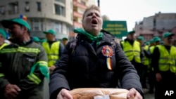 FILE - A woman holds bread during a farmers protest in Bucharest, Romania, April 7, 2023. Poland, Hungary and Slovakia imposed unilateral bans in September on the import of some Ukrainian foods, saying their own farmers were being undercut.