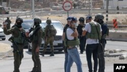 Members of Israeli security forces block a road leading to the site of a reported attack south of Hebron in the occupied West Bank, Aug. 21, 2023. 