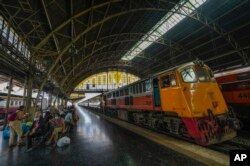 Penumpang menunggu di bangku peron terbuka di stasiun kereta Hua Lamphong di Bangkok, Thailand, Selasa, 17 Januari 2023. (AP/Sakchai Lalit)