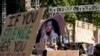 Students hold up a photo of University of Southern California 2024 valedictorian Asna Tabassum in protest to her canceled commencement speech on the campus of University of Southern California, April 18, 2024. 
