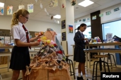 Para siswa menggunakan kertas daur ulang untuk merancang pakaian ramah lingkungan pada kelas seni di sebuah sekolah di Dubai, Uni Emirat Arab, 3 Februari 2023. (REUTERS/Rula Rouhana)