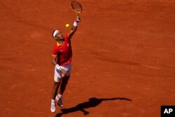 Spain's Rafael Nadal jumps to return the ball to Serbia's Novak Djokovic during their men's singles second round match at the 2024 Summer Olympics, July 29, 2024, at the Roland Garros stadium in Paris, France.