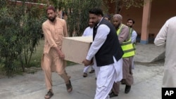 FILE - Volunteers in Basham, Pakistan, on March 26, 2024, carry the casket of a Chinese national killed in a bombing. The Afghan Taliban on May 31 rejected Pakistan's attribution of the blast to militants operating from Afghanistan.