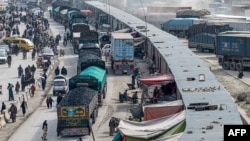 In this photo taken Feb. 2, 2023, Afghan cargo trucks loaded with coal arrive from Pakistan at the Afghanistan-Pakistan Torkham border post in Nangarhar province.