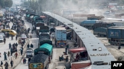 FILE - Afghan cargo trucks loaded with coal arrive from Pakistan at the Afghanistan-Pakistan Torkham border post in Nangarhar province, Feb. 2, 2023. The crossing is set to reopen Sept. 15, 2023, following a security closure.
