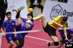 Vietnam's Tran Thi Ngoc Yen (R) defends as Thailand's Sasiwimol Jhanthansit kicks the ball in the women's sepak takraw final between Vietnam and Thailand during last year's Southeast Asian Games (SEA Games) in Hanoi on May 21, 2022.