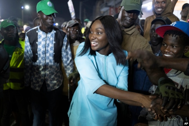 Presidential candidate Anta Babacar Ngom greets supporters during her electoral campaign caravan in Dakar, Senegal, Monday, March 11, 2024. Activists say her presence is helping to advance a campaign to achieve equality in the West African nation. (AP Photo/Sylvain Cherkaoui)