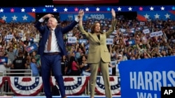 Democratic presidential nominee Vice President Kamala Harris and running mate Minnesota Gov. Tim Walz arrive during a campaign rally at Desert Diamond Arena, Aug. 9, 2024, in Glendale, Ariz.