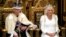 Raja Charles III menunggu untuk membacakan Pidato Raja Inggris, sementara Ratu Camilla duduk di sebelahnya selama Pembukaan Parlemen Inggris di House of Lords, London. Pidato Charles akan memaparkan agenda pemerintahan Partai Buruh pertama di Inggris selama 14 tahun. (AP)&nbsp;