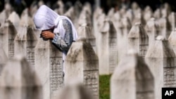 Arhiva - Žena tuguje pored groba svog bližnjeg, žrtve genocida u Srebrenici, u Memorijalnom centru Srebrenica, u Potočarima, 11. jula 2024.