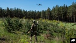 FILE: A Ukrainian Border Guard soldier catches a drone during a military exercise in central Ukraine, Tuesday, May 2, 2023.