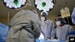 Mahasiswa Meharry Medical College Emmanuel Kotey (tengah) dan Teresa Belledent (kanan), menyaksikan operasi pengambilan hati dan ginjal dari donor organ di Jackson, Tennesse, 15 Juni 2023. (AP/Mark Humphrey)