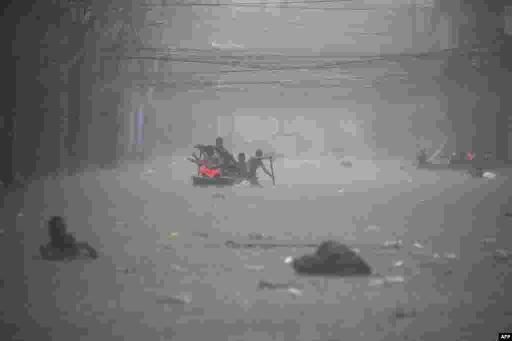 Rescuers paddle their boats along a flooded street in Manila, Philippines amid heavy rains brought by Typhoon Gaemi.