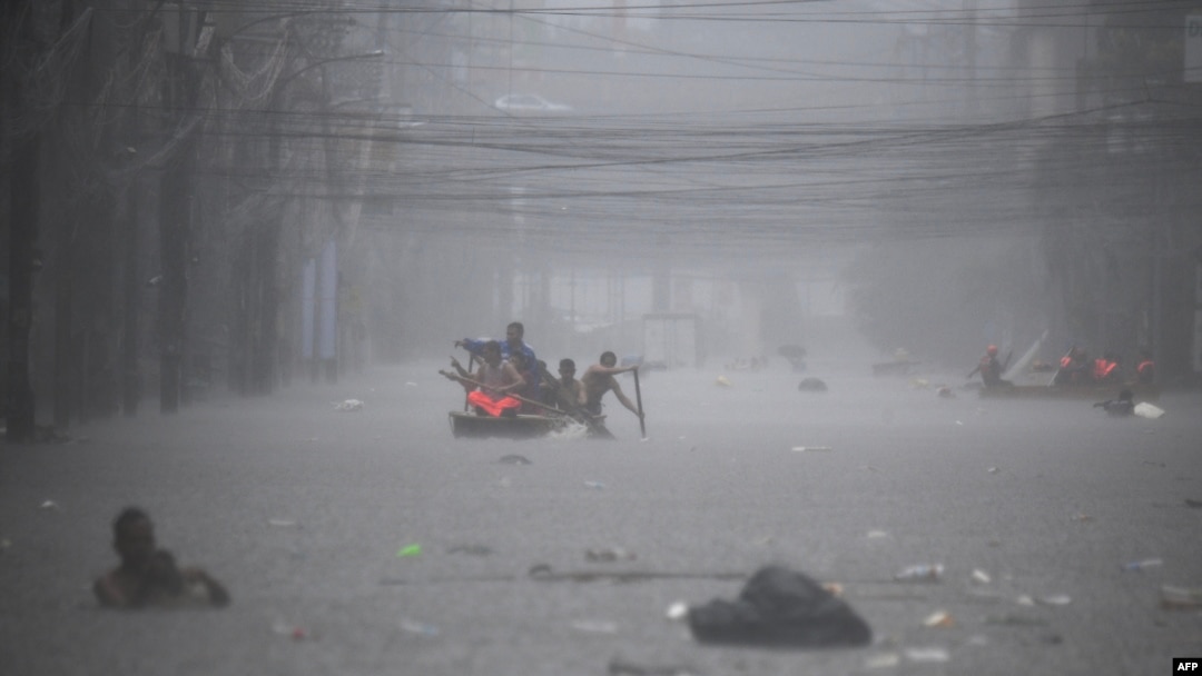 Tim penyelamat mendayung perahu untuk mengevakuasi warga di sepanjang jalan yang terendam banjir di Manila, Filipina akibat hujan lebat yang dibawa oleh Topan Gaemi, Kamis (24/7). 