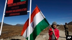 一個印度女孩手舉印度國旗站在印度阿魯納恰爾邦的中印邊界線上。（2012年10月21日）