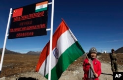 Seorang gadis India berfoto dengan bendera India di perbatasan India-China di Bumla, Arunachal Pradesh, India, 21 Oktober 2012. (Foto: AP)