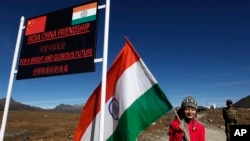资料照：一个印度女孩手举印度国旗站在印度阿鲁纳恰尔邦的中印边界线上。（2012年10月21日）