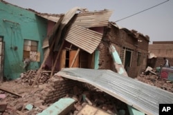 A man walks by a house hit in recent fighting in Khartoum, Sudan, April 25, 2023.