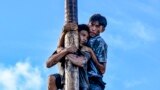 Participants climb a greasy pole called "Panjat Pinang" to collect prizes hung at the top during a continuous celebration since three days of Indonesia's 78th Independence Day, in Banda Aceh, Indonesia, Aug. 20, 2023. 