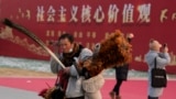 资料照：北京一名街头小贩走过“社会主义核心价值观”的宣传牌。（2024年1月20日）