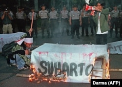 Pelajar membakar peti mati mantan presiden Soeharto di dekat kediaman Soeharto di Jakarta, 16 Agustus 2000. (Foto: AFP/DARMA)