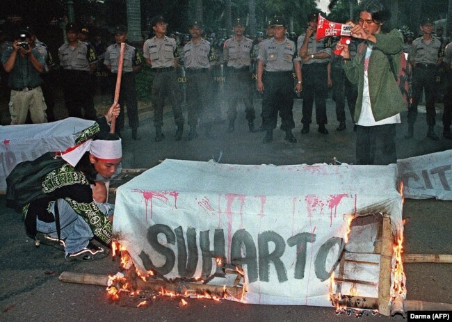 Pelajar membakar peti mati mantan presiden Soeharto di dekat kediaman Soeharto di Jakarta, 16 Agustus 2000. (Foto: AFP/DARMA)