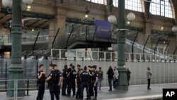 FILE - Police officers patrol inside the Gare du Nord train station at the 2024 Summer Olympics, July 26, 2024, in Paris, France. The French government says multiple telecommunications lines have been hit by acts of vandalism. 