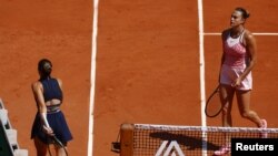 Ukraine's Marta Kostyuk, left, walks past Belarus' Aryna Sabalenka after losing her first round match at the French Open in Paris, France, May 28, 2023.