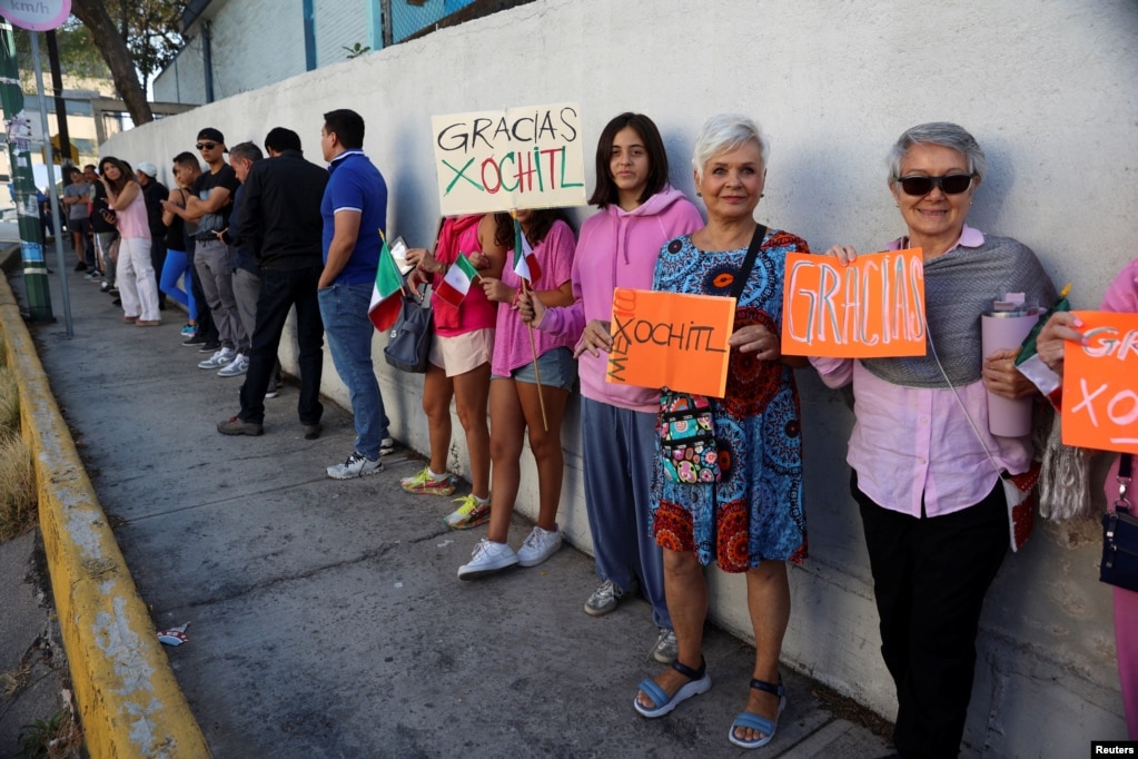 Ciudadanos sostienen carteles en apoyo a la candidata presidencial de la oposición de México, Xochitl Gálvez.