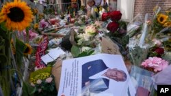 FILE - A photo and floral tributes mark the spot where journalist Peter R. de Vries was shot in Amsterdam, Netherlands, July 8, 2021.