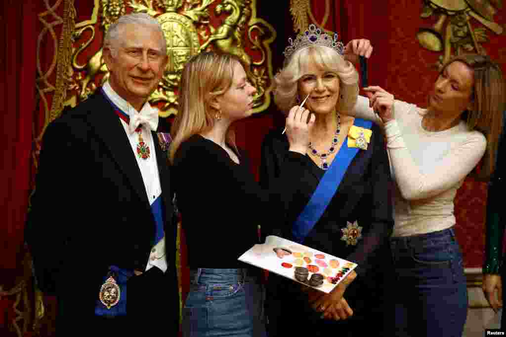 Studio assistants retouch a new waxwork representation of Britain's Queen Consort Camilla as part of the new attraction ‘The Royal Palace’ experience at Madame Tussauds in London, April 26, 2023. 