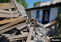 A local resident looks at the ruins of her garage, destroyed by recent shelling, in the town of Horlivka (Gorlovka) in the Donetsk region, Russian-controlled Ukraine, June 5, 2023.