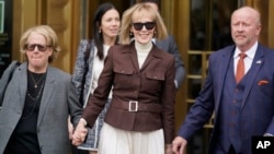 FILE - E. Jean Carroll, center, walks out of Manhattan federal court in New York, May 9, 2023. A federal judge on Tuesday said the New York writer can pursue a $10 million defamation case against the former U.S. president.