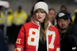 Taylor Swift mengenakan jaket seragam tim Kansas City Chiefs milik Travis Kelce saat hadir di pertandingan NFL antara Kansas City Chiefs dan the Miami Dolphins, 13 Januari, 2024 di Kansas City, Missouri (dok: AP/Ed Zurga)