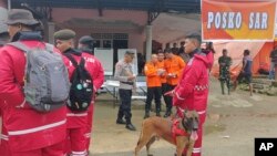 8일 폭우로 산사태가 발생한 인도네시아 술라웨시섬 북부 고란탈로주 보네 발랑고의 금광 앞에 인도네시아 국립 수색 구조국 대원들이 서있다.