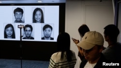 香港当局在记者会上公布被通缉的五位身处海外的香港活动人士照片。（2023年12月14日）