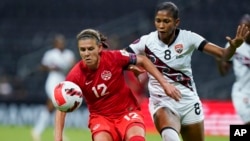 FILE - Canada's Christine Sinclair, left, and Trinidad and Tobago's Victoria Swift compete for the ball during a CONCACAF women's championship soccer match in Monterrey, Mexico, July 5, 2022.