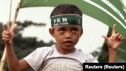 Seorang anak mengikuti kampanye Partai Kebangkitan Bangsa (PKB) di Jakarta Pusat, 26 Mei 1999. (Foto: Reuters)