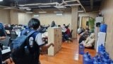 FILE - In this photo provided by the Philippine National Police Anti-Cybercrime Group, police raid an office in Las Pinas, Philippines, on June 27, 2023. The UN says criminal gangs have forced hundreds of thousands of people in Asia into participating in online scam operations.