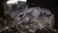 Palestinians inspect the rubble at the site of an airstrike that the Israeli military said targeted the house of an Islamic Jihad member, in Deir al-Balah, central Gaza Strip, May 13, 2023. 
