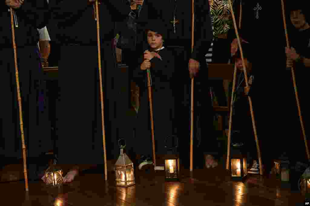 Devotees penitent, known as the Twelve Apostles (Doce Apostoles), pray barefooted inside of a church, as they take part in an annual event in the small village of Olite, northern Spain.