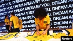 A worker applies the number of Australia's Caitlin Foord to a football jersey in the Nike FC shop in Sydney, Aug. 14, 2023